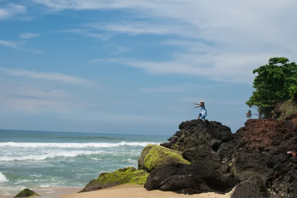 horizontal-shot-female-with-hat-blue-dress-rocky-beach